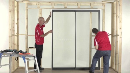 Professional technician using precision 4-foot level and gap measurement tools to diagnose sliding door misalignment and determine adjustment requirements